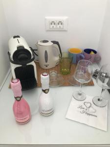 a kitchen counter with two bottles and wine glasses at Yanna Luxury Suites (Asteri Suites) in Ornos