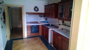 a kitchen with wooden cabinets and a stove top oven at BORMIO Centro storico in Bormio