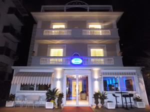 a building with a blue sign on the front of it at Hotel Residence Villa Del Mare in Rimini