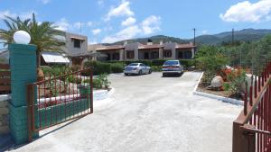 een parkeerplaats met auto's geparkeerd voor een huis bij Villa Katerina Holiday Apartments in Agia Fotia