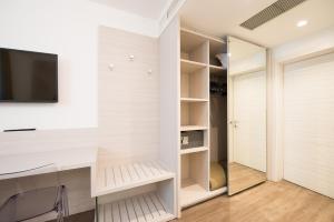 a walk in closet with a tv and a desk at Grand Hotel Liberty in Riva del Garda