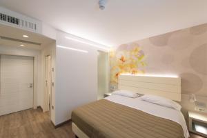a bedroom with a bed and a painting on the wall at Grand Hotel Liberty in Riva del Garda