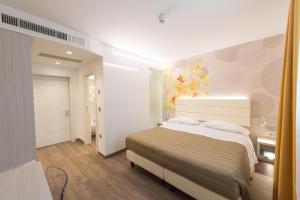 a bedroom with a bed and a painting on the wall at Grand Hotel Liberty in Riva del Garda