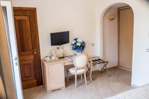 a room with a desk with a television and a chair at Hotel Villa Ceselle in Anacapri