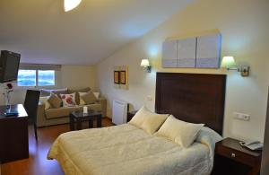 a bedroom with a bed and a living room at Hotel & Spa PLAZA Arriate in Arriate