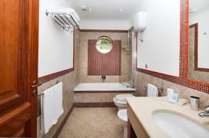 a bathroom with a toilet and a tub and a sink at Hotel Villa Ceselle in Anacapri