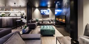 uma sala de estar com sofás e uma lareira em Mair Am Ort Living Hotel B&B em Parcines