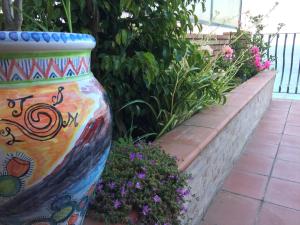 a large colorful vase sitting next to some flowers at B&B La Terrazza Sul Mare Taormina in Taormina