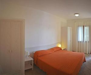a bedroom with a bed with an orange blanket at Residenza Le Sprizze in Bagno +47 photos