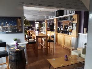 a restaurant with a bar with wooden tables and chairs at Sutherlands Hotel in Gateshead