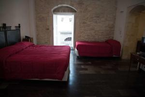 a bedroom with two beds and a window at Hotel Dell'Orologio in Ragusa
