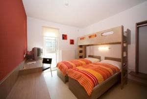 1 dormitorio con 1 cama y TV. en Nibelungenmotel Pöchlarn, en Pöchlarn