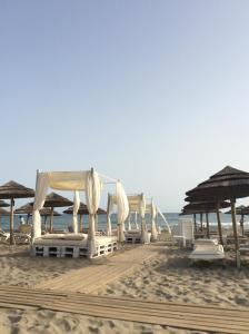 szereg leżaków i parasoli na plaży w obiekcie Apartamento Hacienda San Manuel w Marbelli