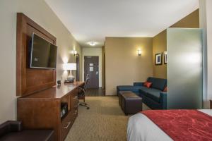 a hotel room with a bedroom with a bed and a couch at Comfort Suites Regina in Regina