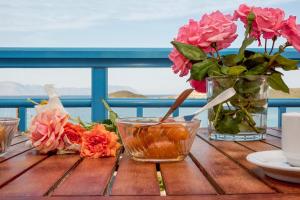 a table with flowers and a vase of flowers at Athena Kythera in Dhiakofti
