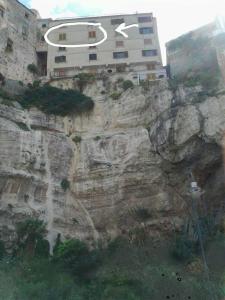 a building on the side of a rock cliff at Elianto in Tropea
