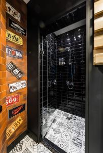 uma casa de banho com um chuveiro com azulejos pretos e brancos em 5 Vintage Guest House em Sófia