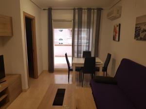 een woonkamer met een tafel en stoelen en een raam bij Apartamento Costa Marina III Magic World in Oropesa del Mar