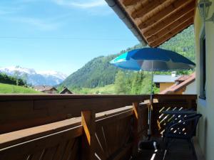 a blue umbrella sitting on top of a balcony at Haus Mary in Russbach am Pass Gschütt