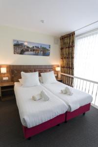 um quarto com uma cama grande com duas toalhas em Hotel Park Plantage em Amsterdã