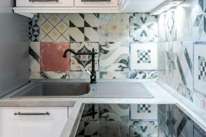 a kitchen with a sink and tiles on the wall at Tajla Rooms in Split