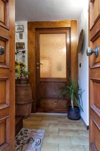 een houten deur in een hal met een potplant bij Il Nido Di Asia in Cortona