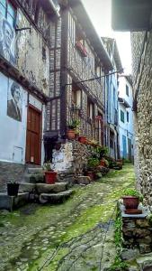 un callejón con un edificio con macetas. en Apartamento Rural El Pino, en Mogarraz