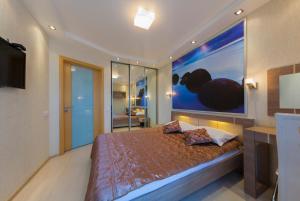 a bedroom with a bed and a large painting on the wall at Apartment Prestige Hall in Kyiv