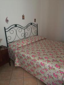 1 Schlafzimmer mit einem Bett mit Blumenbettdecke in der Unterkunft Bixio Apartments in San Vito lo Capo