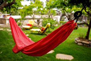 a red hammock hanging from a tree in a yard at Terrace Apartment in Hvar