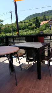 a table and chairs on a balcony with a view of a mountain at Római Apartman in Badacsonytomaj