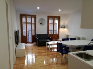 a kitchen and living room with a couch and a table at Calle Ansoleaga a 100 mts del Ayuntamiento in Pamplona