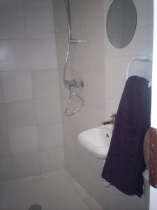 een badkamer met een wastafel en een douche met een blauwe handdoek bij L'Espaviot aux portes du Puy en Velay in Espaly-Saint-Marcel