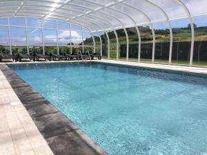une grande piscine avec un toit clair dans l'établissement Vale dos Cocos, à Horta
