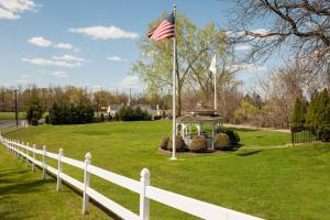 a white fence and a gazebo with an american flag at The Kenilworth Hotel - Airport West in Kenilworth