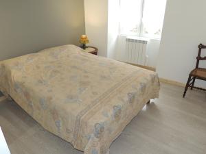 een bed in een slaapkamer met een deken erop bij L'Espaviot aux portes du Puy en Velay in Espaly-Saint-Marcel