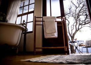 a bathroom with a bath tub and a towel on a chair at Mon-Ae Guesthouse in Klerksdorp