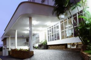 um edifício com janelas e palmeiras em frente em JVA Fenix Hotel em Uberlândia