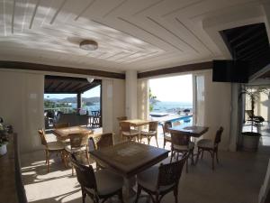 a restaurant with tables and chairs and a view of the ocean at Pousada Ao Por do Sol in Búzios