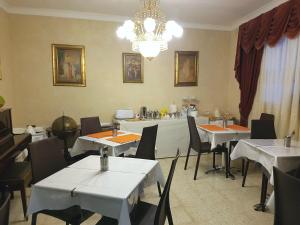 un comedor con mesas y sillas y una lámpara de araña en D'Ambrogio Guest House, en Rabat