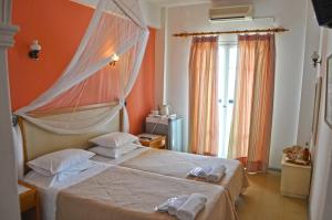 a bedroom with a bed with towels on it at Eros Beach Hotel in Benitses