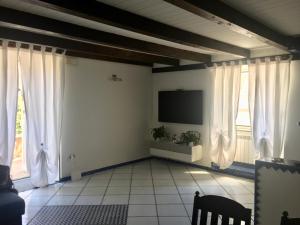 ナポリにあるNAPOLI OVER POSILLIPOのリビングルーム(白いカーテン、薄型テレビ付)