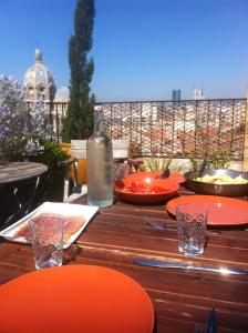 una mesa de madera con platos naranjas y una botella de vino en Adoramaar- le loft, en Marsella