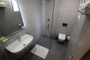 a bathroom with a shower and a sink and a toilet at Hotel Ari in Sarandë
