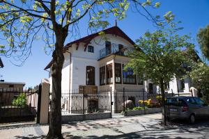 ein weißes Haus mit einem davor geparkt in der Unterkunft Villa Mistral in Ustka