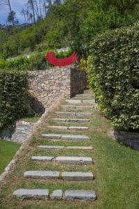 un sentiero in pietra in un giardino accanto a un muro di pietra di Casa Rea a Beverino