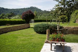 un jardín con un banco con flores en Casa Rea, en Beverino