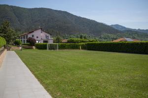 a lawn with a house and mountains in the background at Casa Rea in Beverino