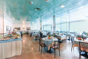 a dining room with tables and chairs in a restaurant at Hotel Mirage in Lido di Classe