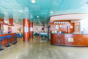 una zona de espera en un hospital con taburetes azules en Hotel Mirage en Lido di Classe